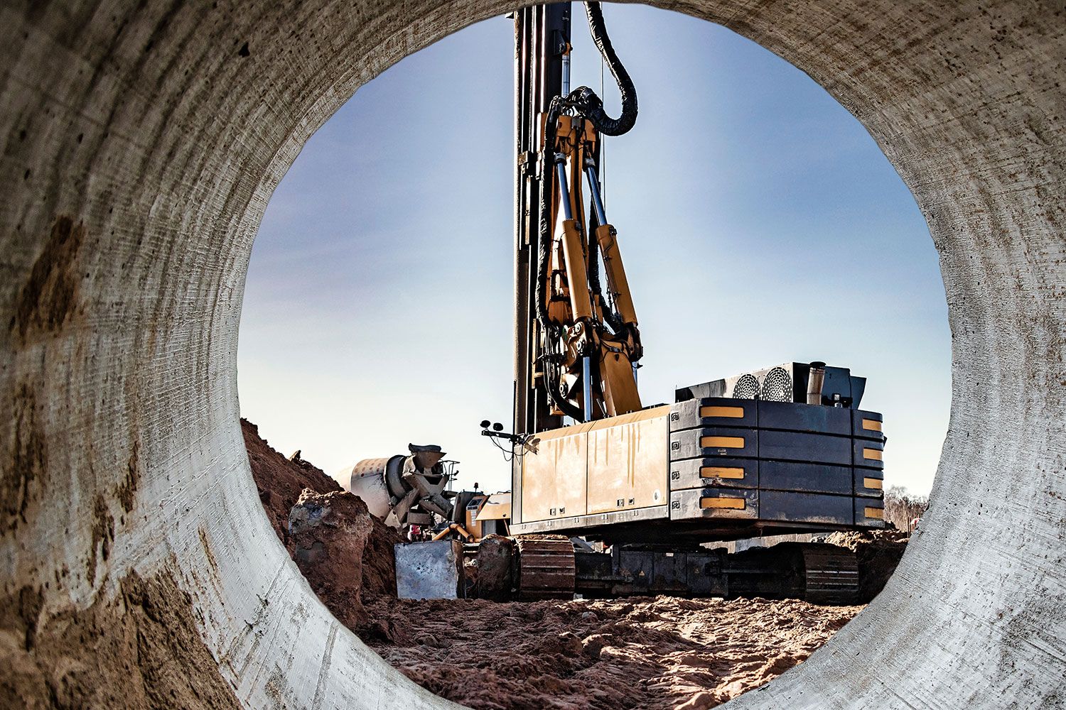Aus einem Betontunnel heraus erkennt man eine Baustelle